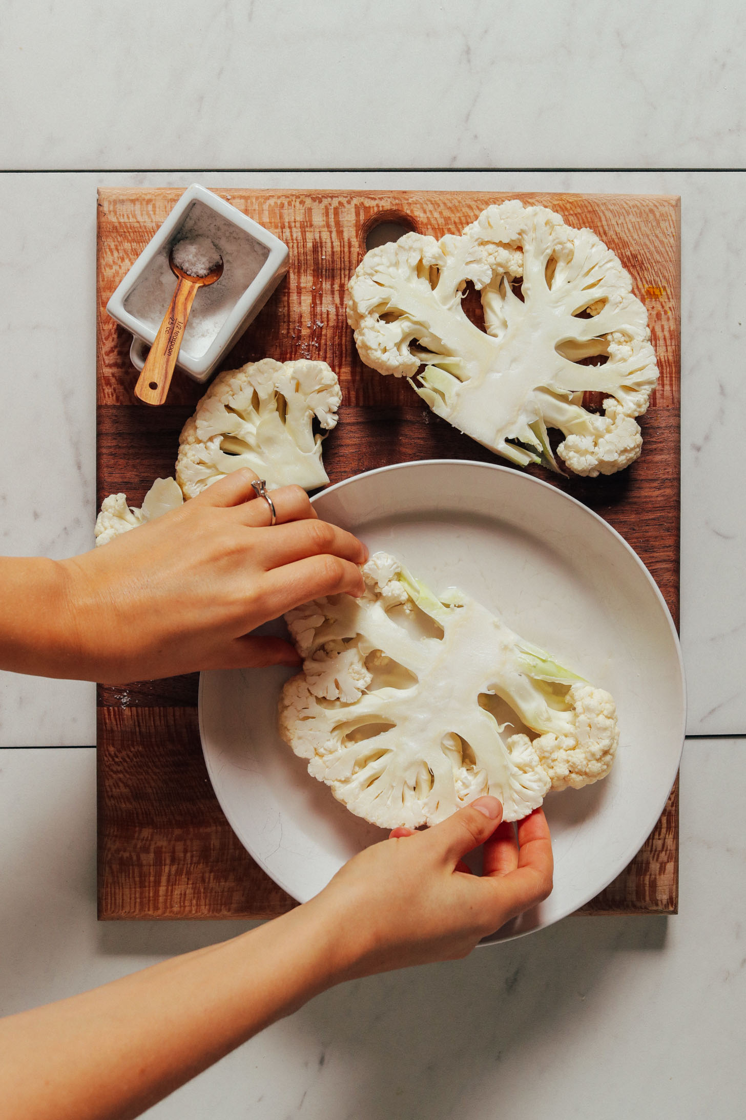 Coating cauliflower in a bowl of dairy-free milk before dipping in crust batter
