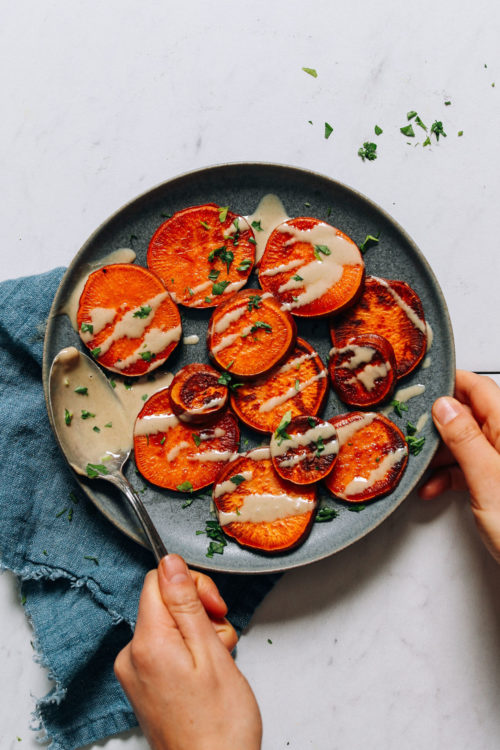 Plate of quick and easy sweet potatoes drizzled with tahini