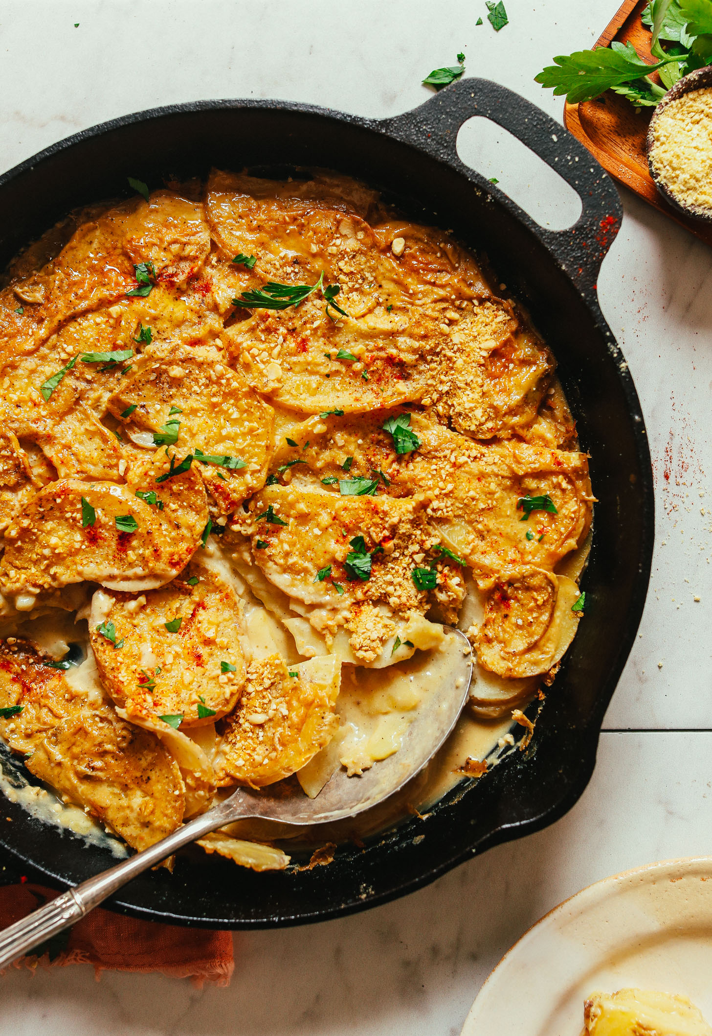 Cast-iron skillet filled with a batch of easy Vegan Scalloped Potatoes