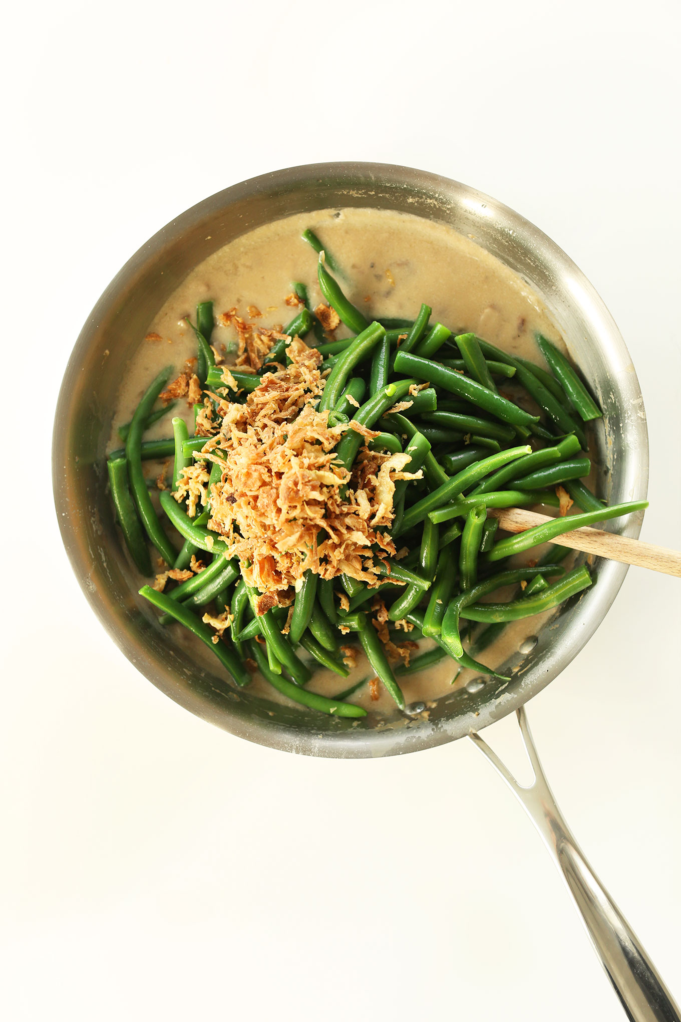 Using a wooden spoon to stir together our Easy Green Bean Casserole recipe