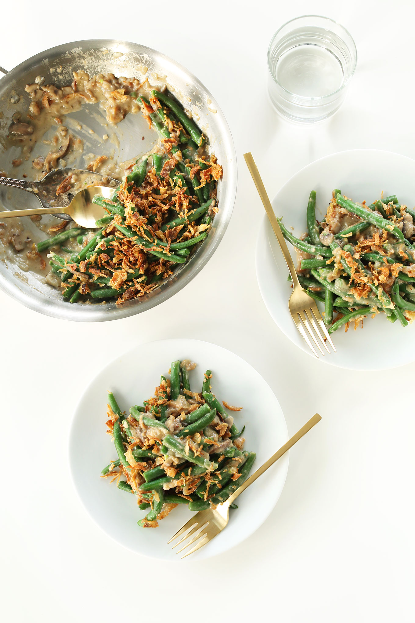 Using a spoon to scoop Vegan Green Bean Casserole onto serving plates